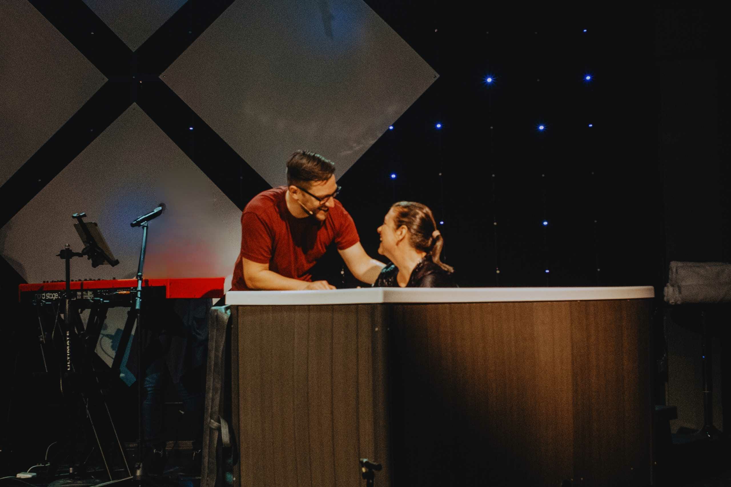 A pastor talks to a woman in the baptismal before she is baptized.